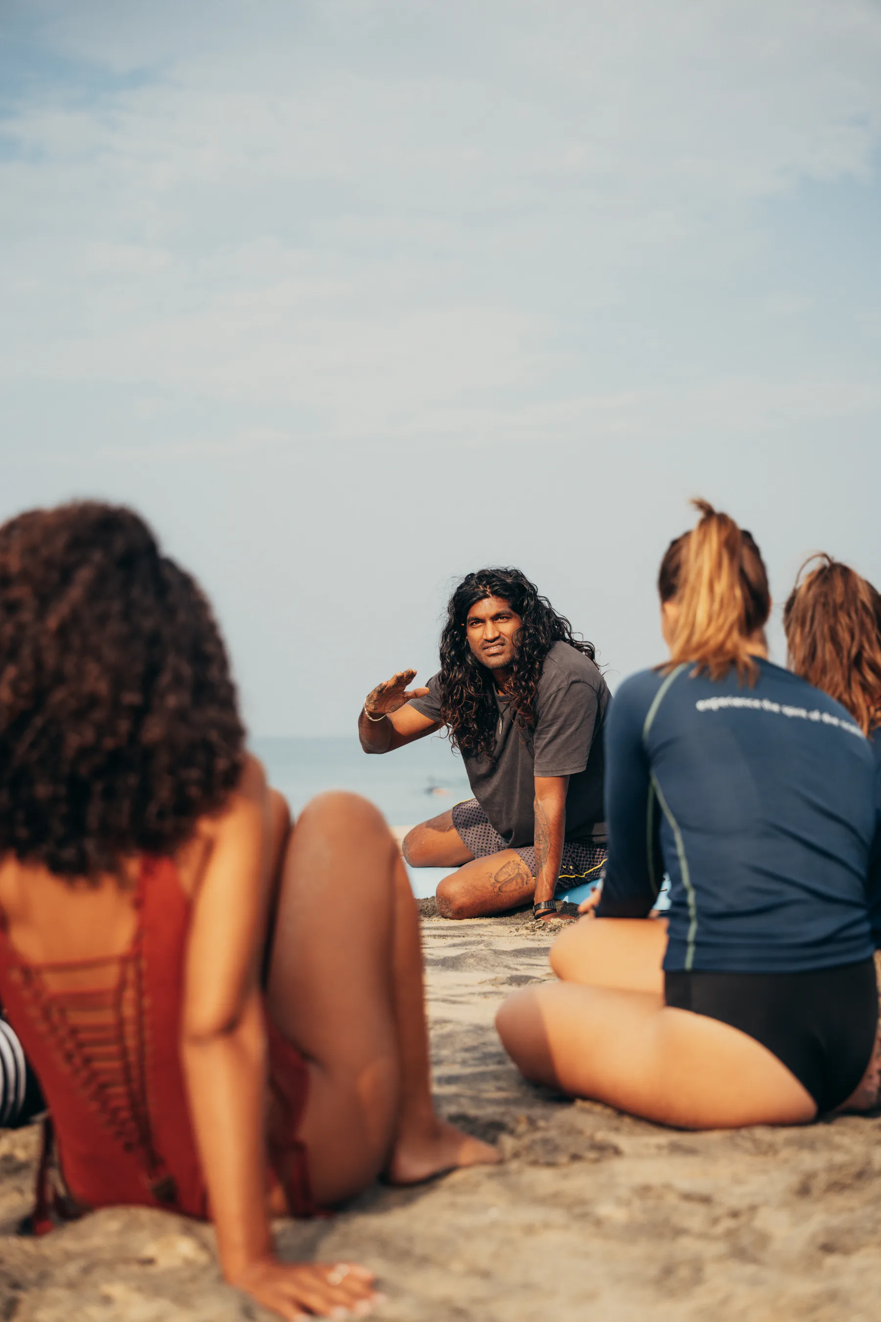 A Paddlecult coach speaking with surfers on the beach
