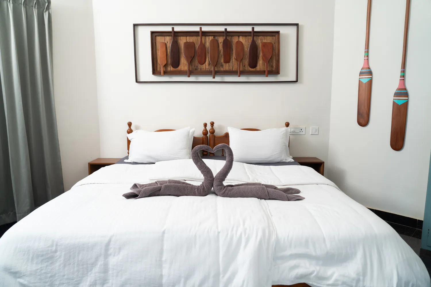 Paddlecult bedroom with white bedding and wooden paddles on the wall
