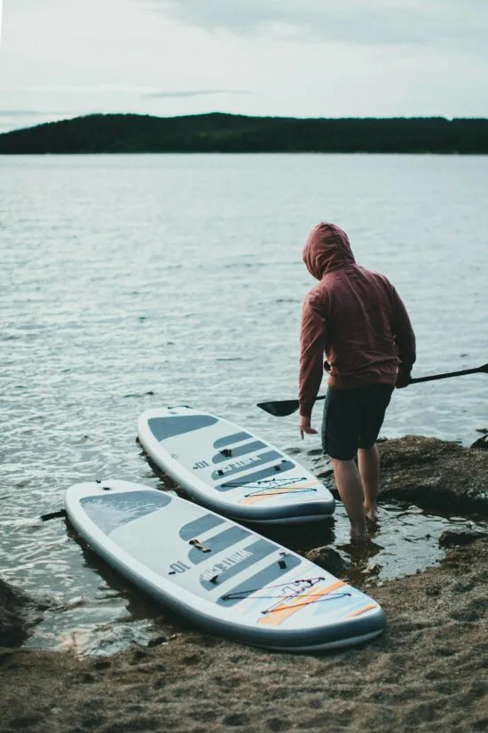 Paddleboards ready beside the water in an illustrative activity photograph