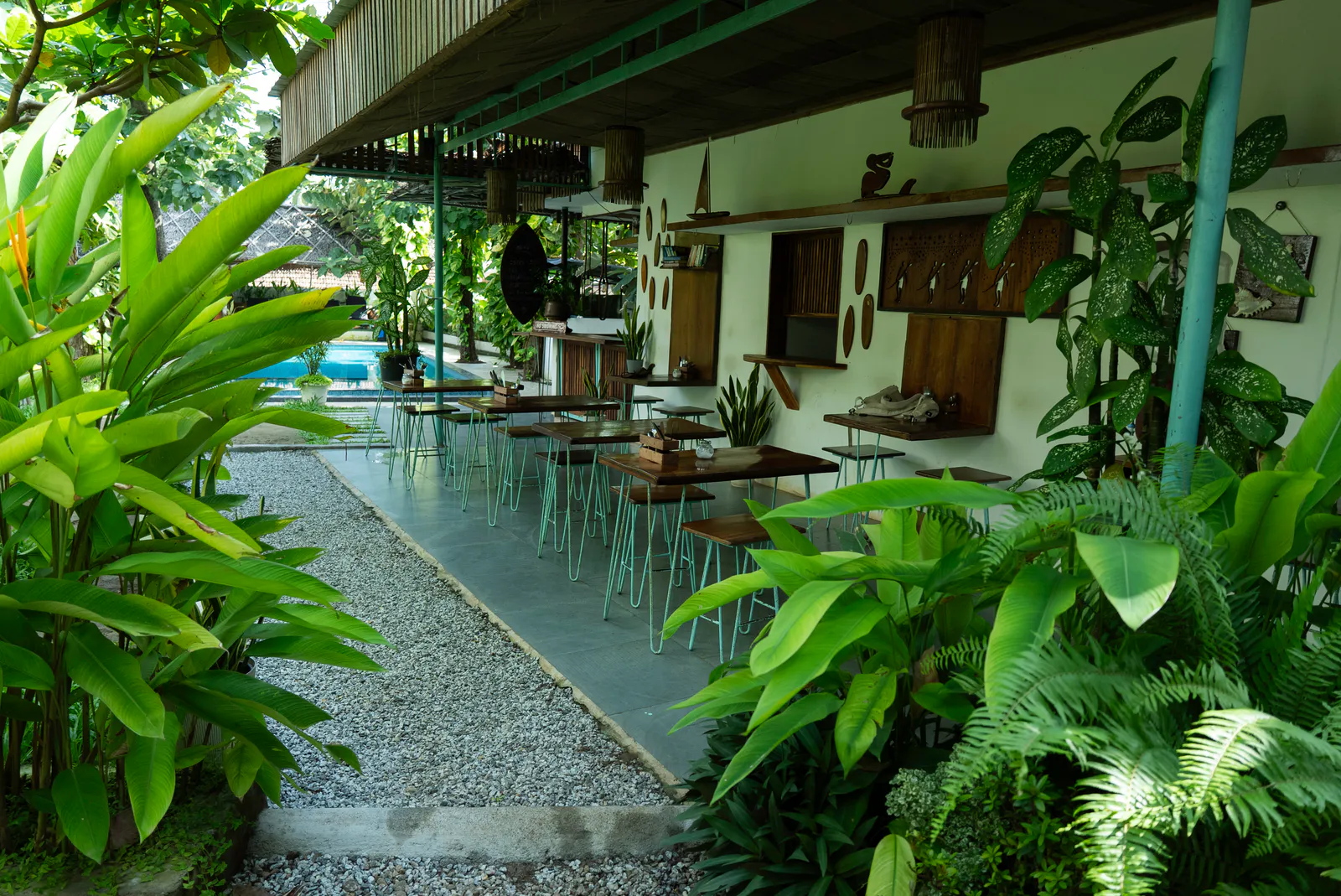 Tables along Paddlecult’s leafy café veranda beside the pool