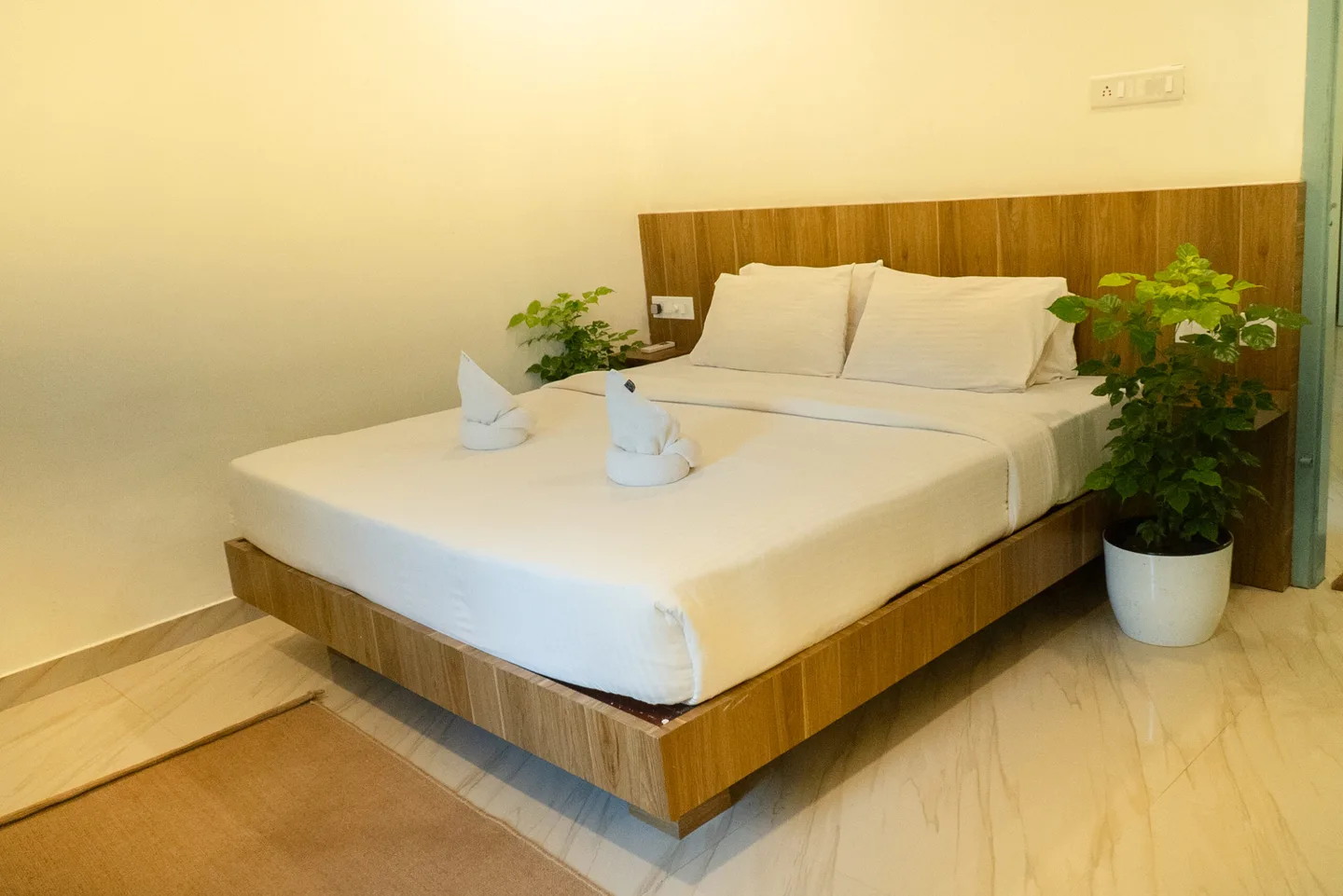 Double bed, wooden headboard and marble-pattern floor